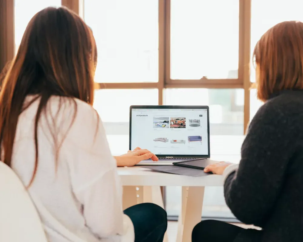 Two colleagues reviewing a website project together on a laptop