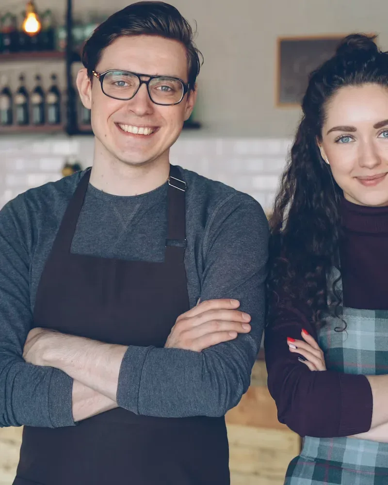 Two café owners standing proudly together in their shop